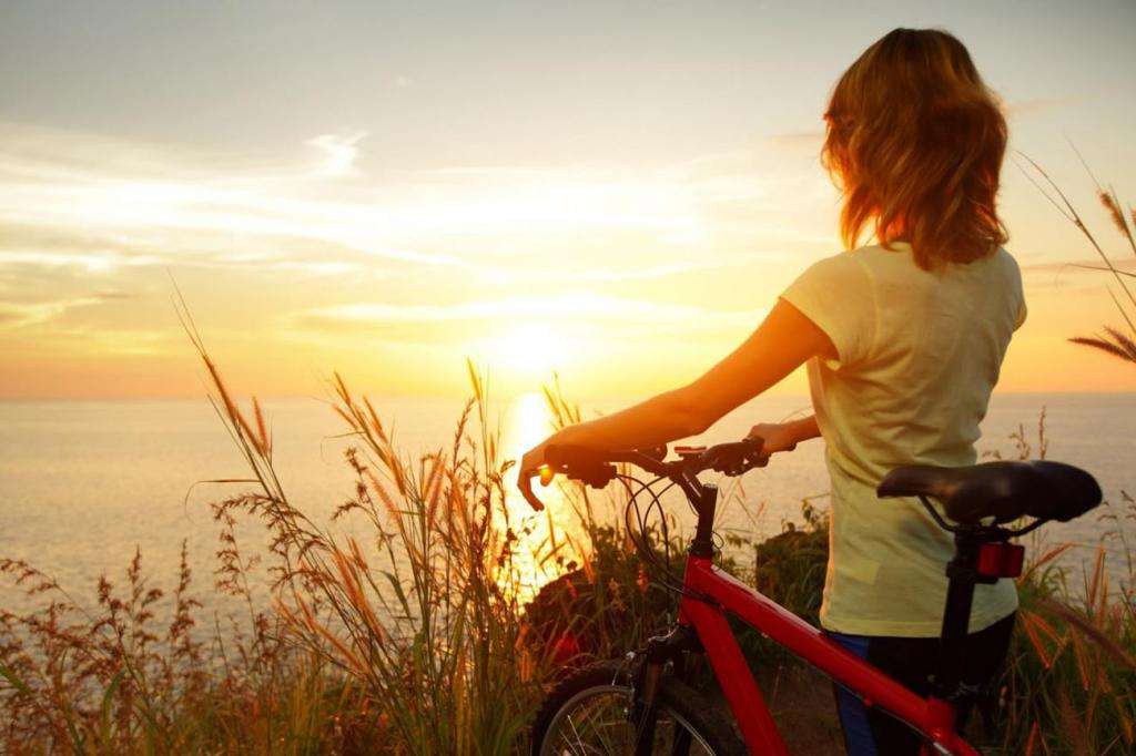 девушка с велосипедом смотрит на закат